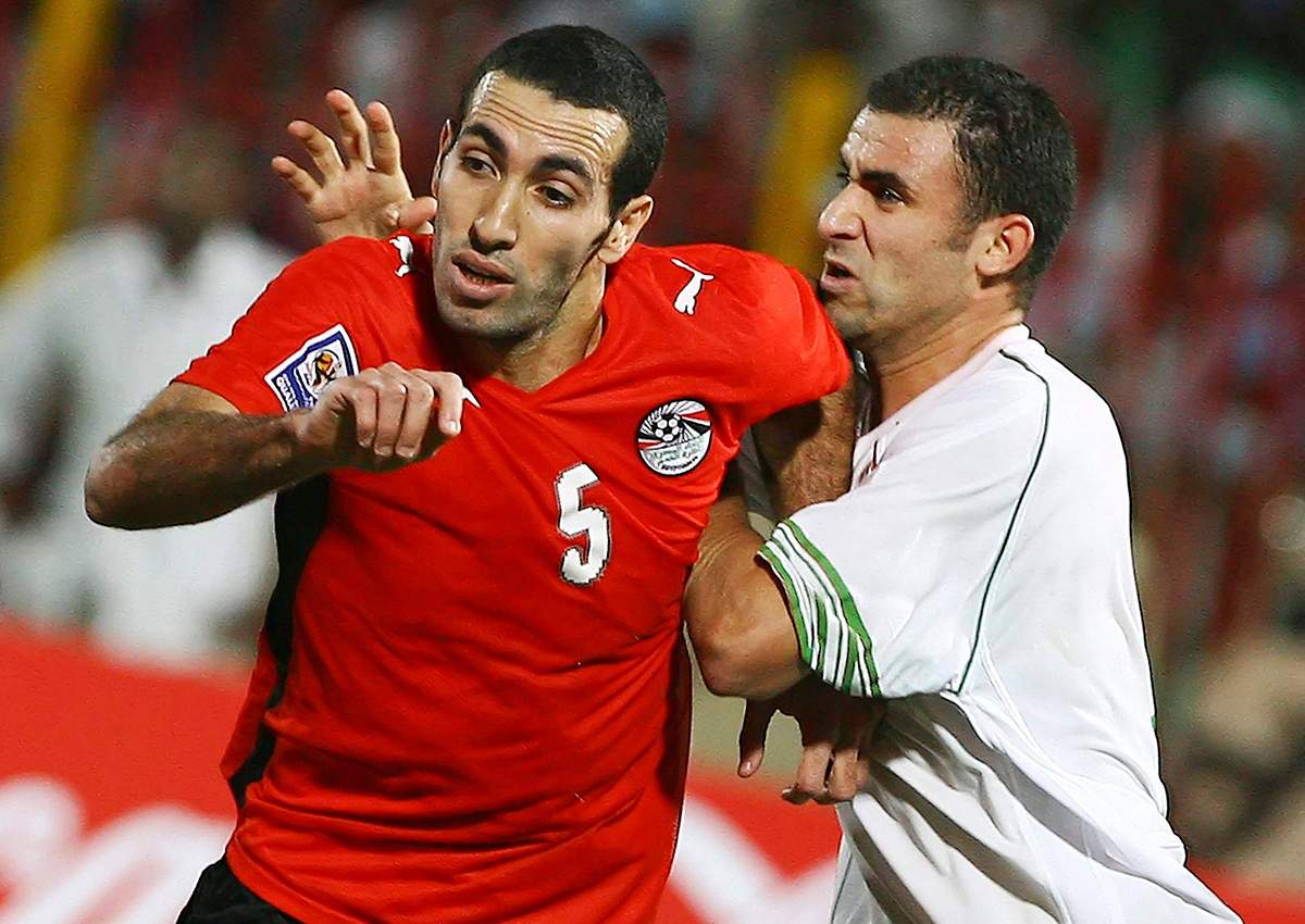 Egyptian soccer player Mohamed Aboutrika, left, is caught by  Algerian Yazid Mansouri, during their World Cup qualifying playoff  Group Csoccer match in Khartoum, Sudan, Wednesday, Nov. 18, 2009. 