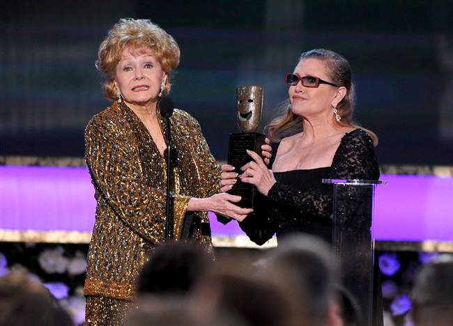 Carrie Fisher, right, presents her mother Debbie Reynolds with the Screen Actors Guild life achievement award at the 21st annual Screen Actors Guild Awards at the Shrine Auditorium in Los Angeles in this Jan. 25, 2015 file photo.