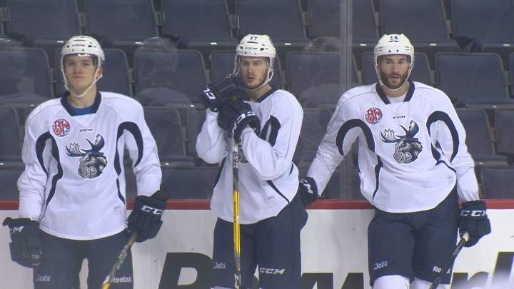 Anthony Peluso (right) waits along the boards with Jimmy Lodge and Jack Roslovic during a Manitoba Moose practice on Dec. 12, 2016.
