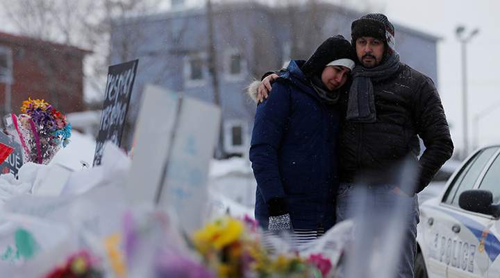 Azzedine Najd and his wife Fadwa Achmaoui look at the memorial near the site of a fatal shooting at the Quebec Islamic Cultural Centre in Quebec City on January 31, 2017. 