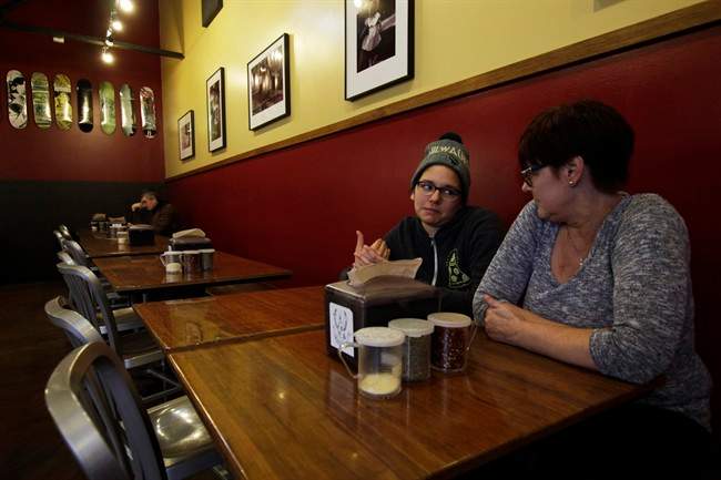 In this Jan. 9, 2017, photo, Andrea Ledesma, 28, second from right, talks with her mother, Cheryl Romanowski, at Classic Slice pizza restaurant, where Ledesma works, in Milwaukee. 