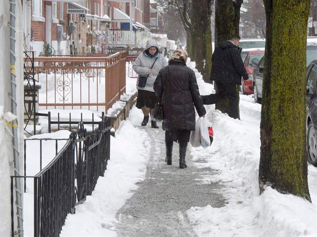 Pedestrians make their way down a snow covered sidewalk Thursday, January 26, 2017 in Montreal. Since announcing the project in 2015, Montreal has been slowly moving ahead with a plan to install heated sidewalks on one of its key downtown arteries. 