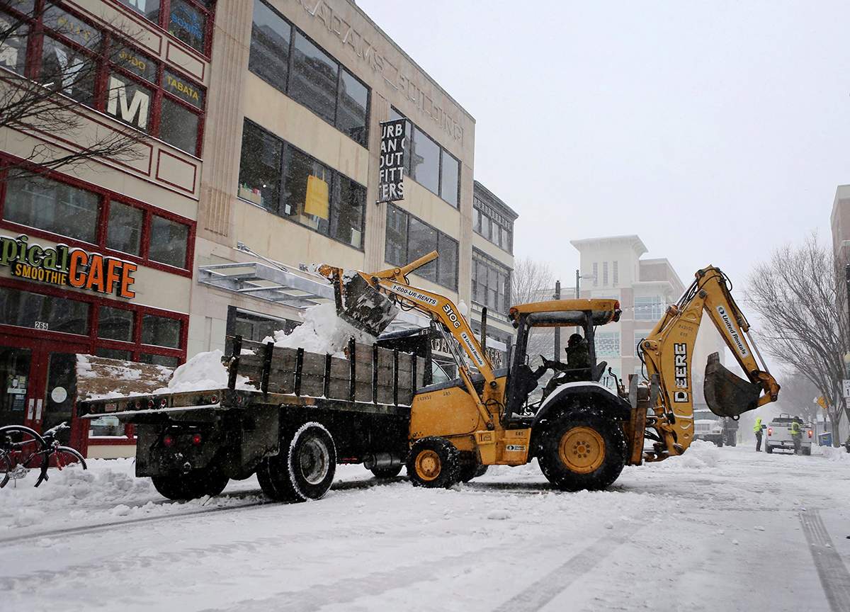 Road crews clear the street during a snowstorm on Saturday, Jan. 7, 2016 in Norfolk, Va. Snow pounded a swath of Virginia on Saturday as hundreds crashed on icy roads, thousands lost power and blizzard warnings were issued along the East Coast. (AP Photo/Jason Hirschfeld)