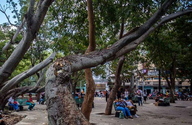 In this Jan. 6, 2017 photo, people use a public wifi hotspot in Havana, Cuba. Cuba depended on slow, expensive satellite internet until 2013, when it opened a fiber-optic cable to Venezuela that connected the island to the global online infrastructure.