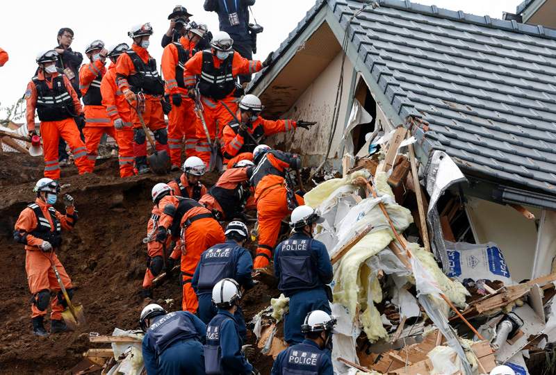 Rescue workers search for missing people at the site of a landslide triggered by an earthquake in southwestern Japan, 19 April 2016. 