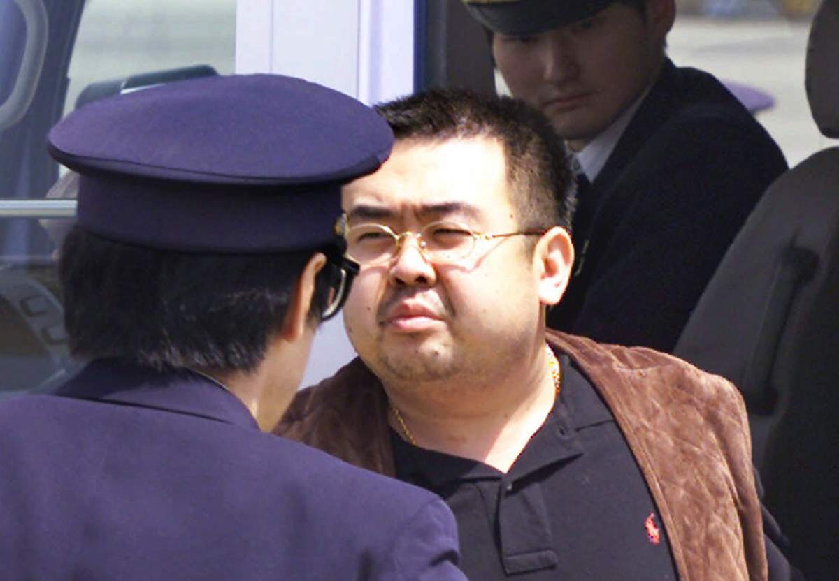 This May 4, 2001, file photo shows Kim Jong Nam, exiled half-brother of North Korea’s leader Kim Jong-un, escorted by Japanese police officers at the airport in Narita, Japan.