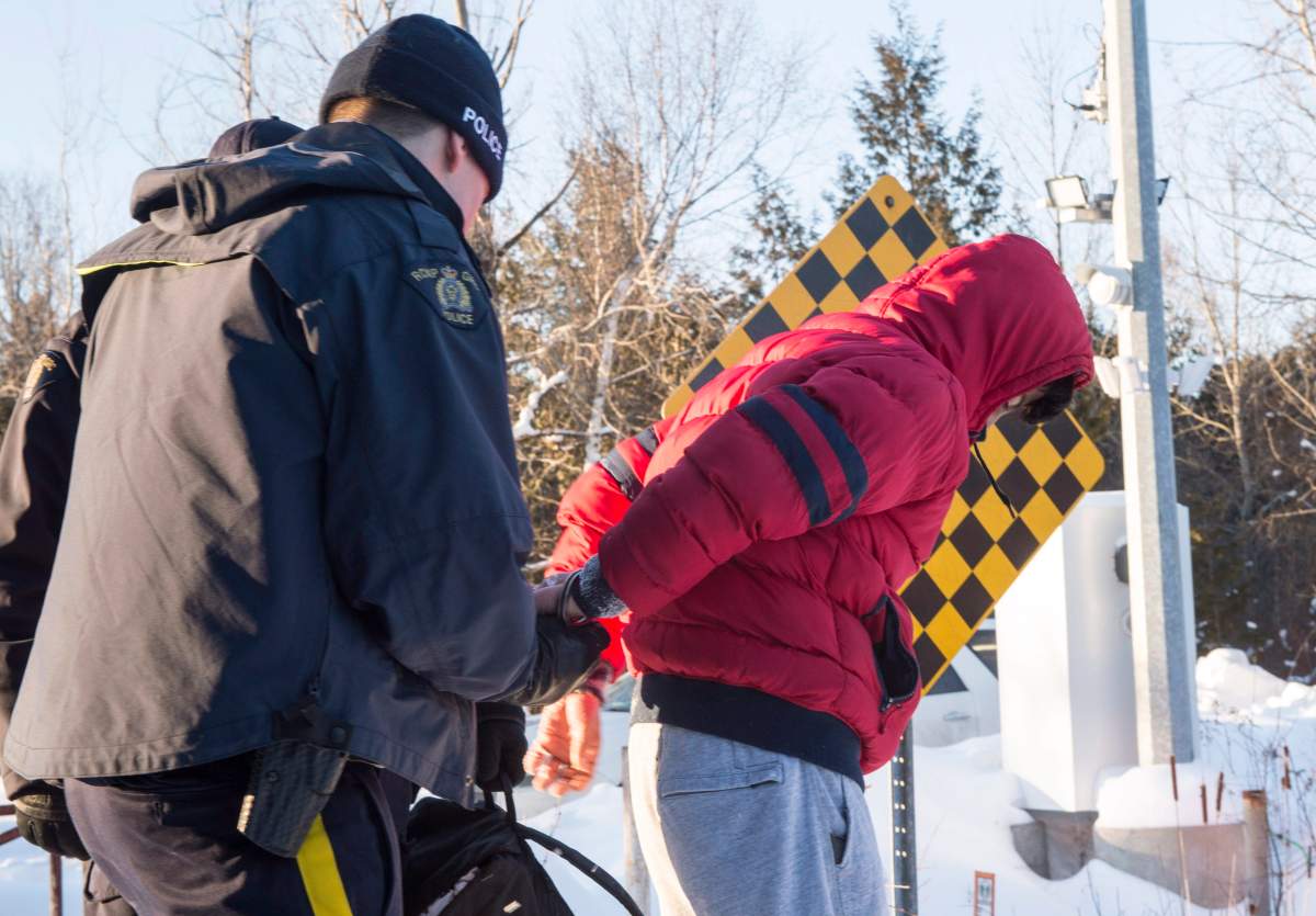A young man from Yemen is arrested by an RCMP officer on the U.S.-Canada border near Hemmingford, Que., on Friday, Feb. 17, 2017. A number of refugee claimants are braving the elements to illicitly enter Canada.