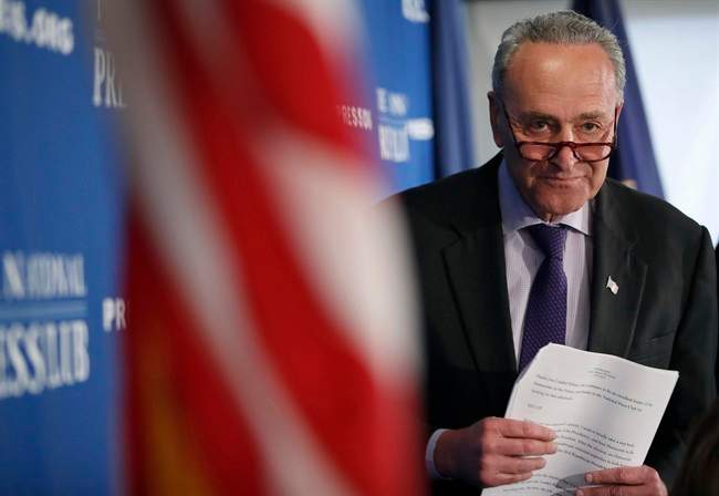 Senate Minority Leader Chuck Schumer of N.Y. walks back to his seat after giving opening remarks during a news conference at the National Press Club in Washington, Monday, Feb. 27, 2017.