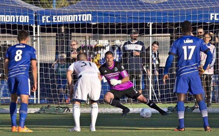 Vancouver Whitecaps' Russell Teibert (31) watches the ball go past Edmonton FC goalkeeper Matt VanOekel (1) as Ritchie Jones (8) and Lance Laing (17) look on during first half action of the Amway Canadian Championship semi-final in Edmonton, Alta., on Wednesday May 20, 2015. 
