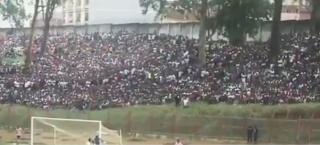 Screenshot from a news report shows crowds massed behind the goal.