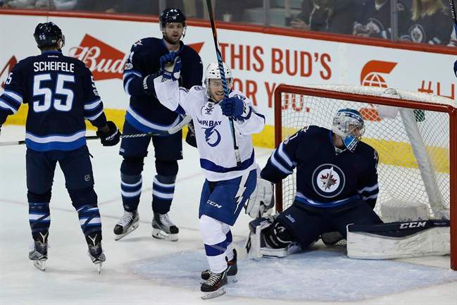 Tampa Bay Lightning centre Brayden Point (21) celebrates his goal on Winnipeg Jets goalie Connor Hellebuyck (37) as centre Mark Scheifele (55) and defenceman Josh Morrissey (44) defend during first period NHL action in Winnipeg on Saturday, February 11, 2017.