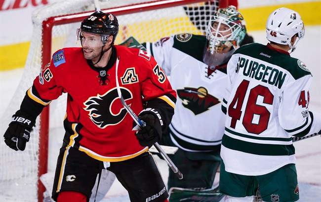 Minnesota Wild defenceman Jared Spurgeon (46) and goalie Devan Dubnyk (40) look away as Calgary Flames right wing Troy Brouwer (36) celebrates a goal during third period NHL hockey action in Calgary, Wednesday, Feb. 1, 2017. 