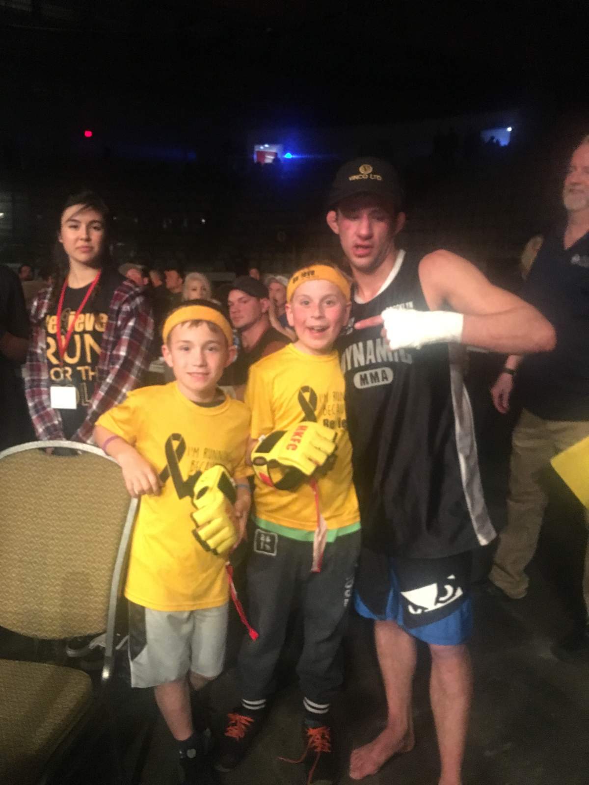 Keegan Oliver posing with a couple of kids from Believe in the Gold after his fight at Hard Knocks 49 in Calgary.