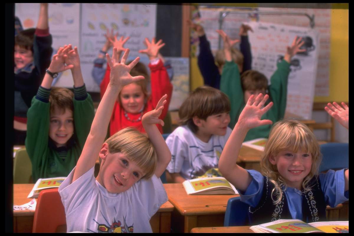 Hands-raising children in French language class at English-speaking school in Montreal, Canada. 