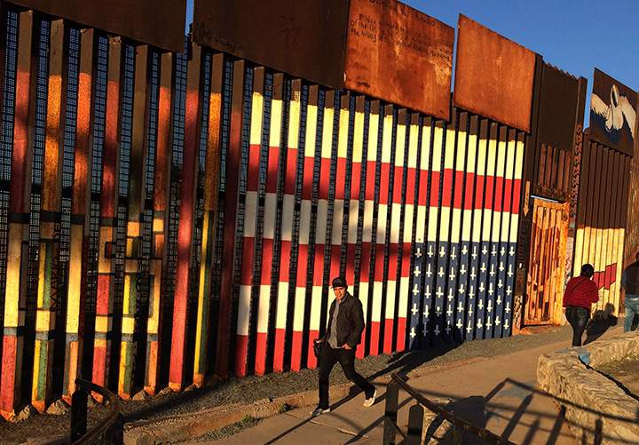 People walk past a mural painted on a border structure in Tijuana, Mexico, on Wednesday, Jan. 25, 2017. 