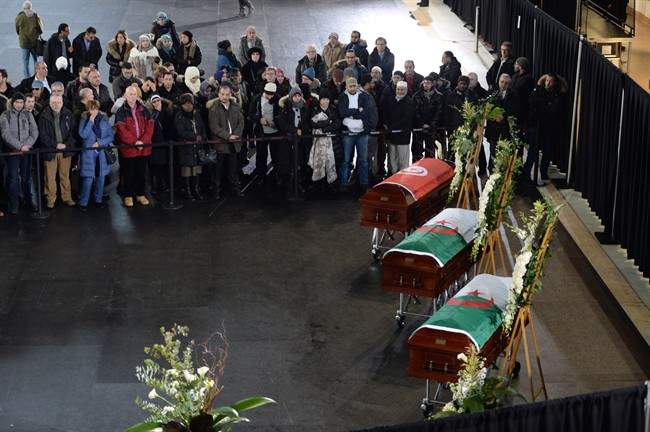 Mourners look on as the caskets of three of the victims of the Quebec City mosque shooting are lined up before a funeral at the Maurice Richard Arena in Montreal, Thursday, February 2, 2017.