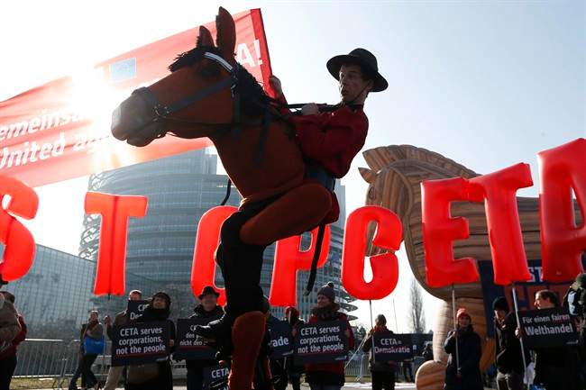 Activists stage a demonstration against CETA, the Canada-EU trade deal, outside the European Parliament in Strasbourg, eastern France, Wednesday, Feb. 15, 2017. Will extent to which the trade deal will help Canadians is yet to be seen.