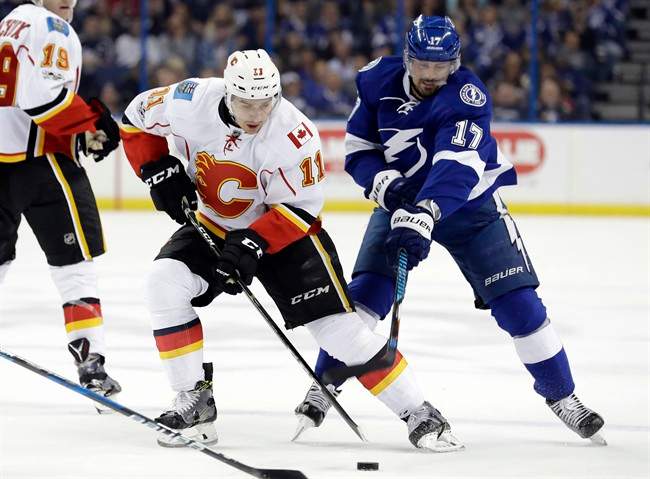 Calgary Flames center Mikael Backlund (11), of Sweden, gets hooked by Tampa Bay Lightning left wing Alex Killorn (17) during the first period of an NHL hockey game Thursday, Feb. 23, 2017, in Tampa, Fla. 