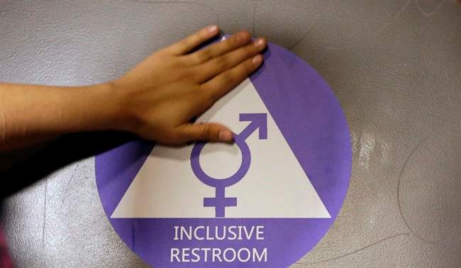 In this May 17, 2016 file photo, a new sticker is placed on the door at the ceremonial opening of a gender neutral bathroom at Nathan Hale High School in Seattle. 