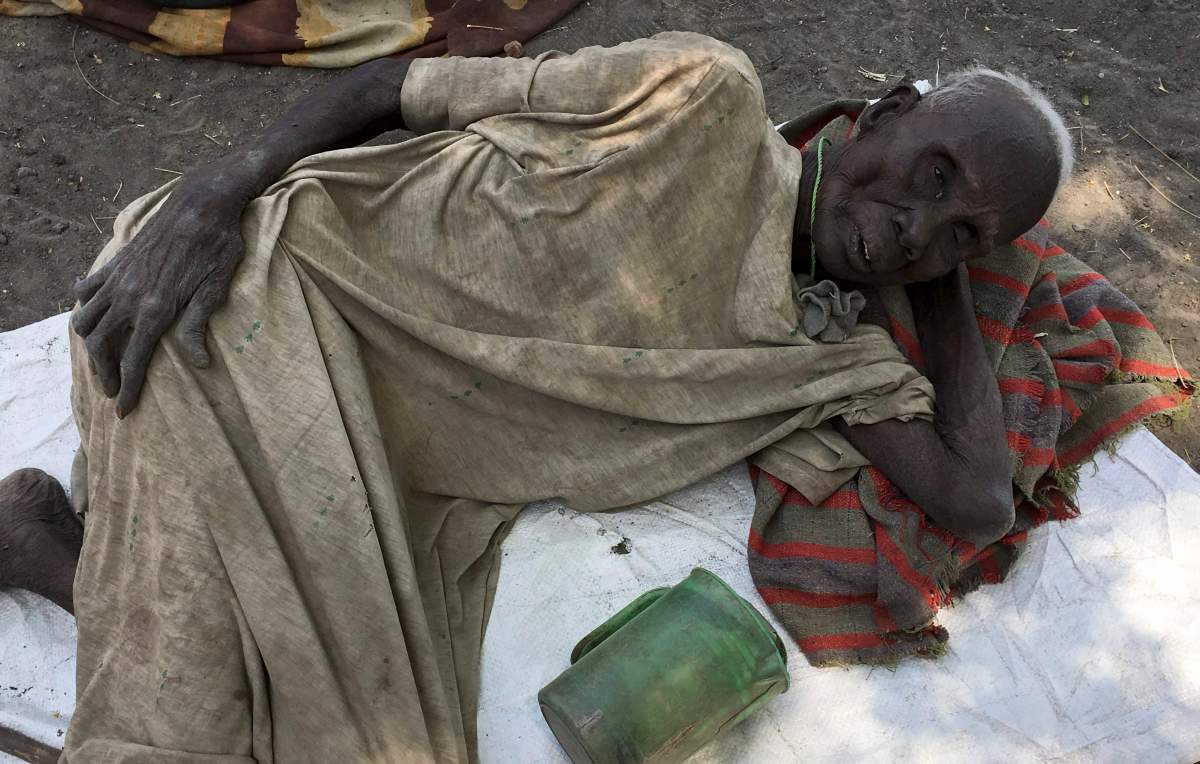 In this photo taken Wednesday, March 1, 2017, Juang Gai Vol, 87, who hadn’t eaten for three days, lies down at a food distribution site in Padeah, South Sudan. South Sudanese who fled famine and fighting in Leer county emerged from South Sudan’s swamps after months in hiding to receive food aid being distributed by the World Food Program. (AP Photo/Sam Mednick)