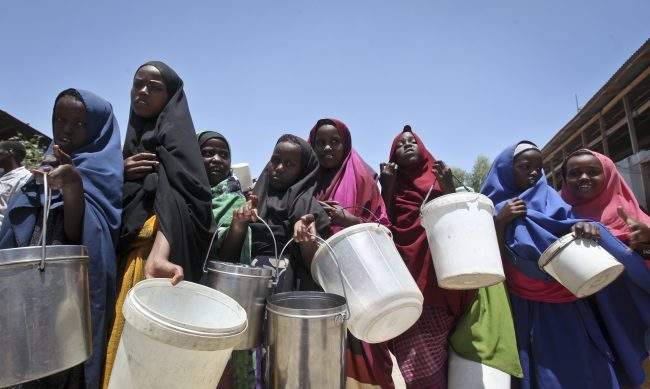 Displaced Somali girls who fled the drought in southern Somalia stand in a queue to receive food handouts at a feeding center in a camp in Mogadishu, Somalia, Feb. 25, 2017.