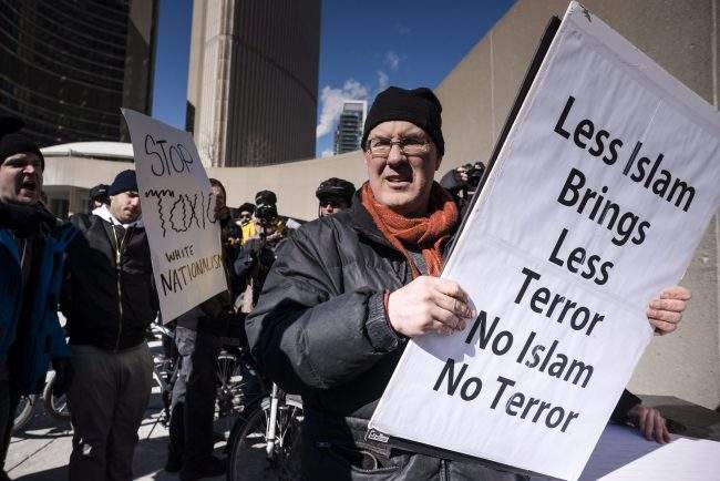 An anti-Islamic protester is pursued by a group of protesters with opposing views during a demonstration regarding motion M-103 at Toronto City Hall on Saturday, March 4, 2017. 
