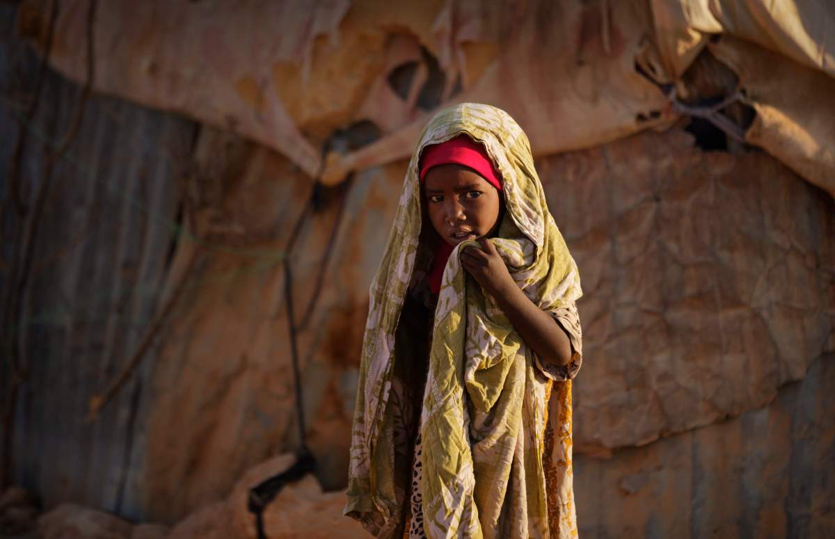 A young Somali girl stands outside her makeshift hut at a camp of people displaced from their homes elsewhere in the country by the drought, shortly after dawn in Qardho, Somalia Thursday, March 9, 2017. Somalia’s government has declared the drought a national disaster, and the United Nations estimates that 5 million people in this Horn of Africa nation need aid, amid warnings of a full-blown famine. (AP Photo/Ben Curtis)