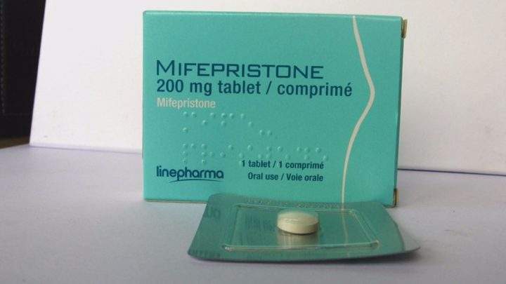 A tablet of mifepristone is pictured in a green package.