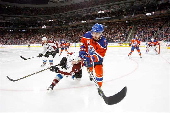 Edmonton Oilers' Andrej Sekera (2) vies for the puck against Colorado Avalanche's Mikko Rantanen (96) during third period NHL action in Edmonton on Saturday, March 25, 2017.