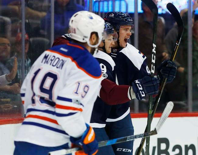 Colorado Avalanche right wing Mikko Rantanen, back, of Finland, celebrates scoring a goal with center Nathan MacKinnon, center, as Edmonton Oilers left wing Patrick Maroon looks on in the first period of an NHL hockey game Thursday, March 23, 2017, in Denver.
