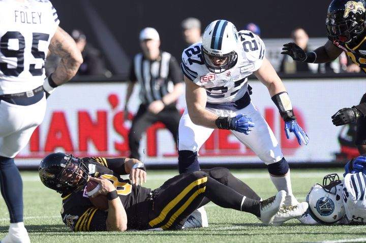 Toronto Argonauts' Cory Greenwood (27) stands over Hamilton Tiger-Cats' Jeremiah Masoli (8) during first half CFL Eastern Division Semifinal football action, in Hamilton, Ont., on Sunday, Nov. 15, 2015. 