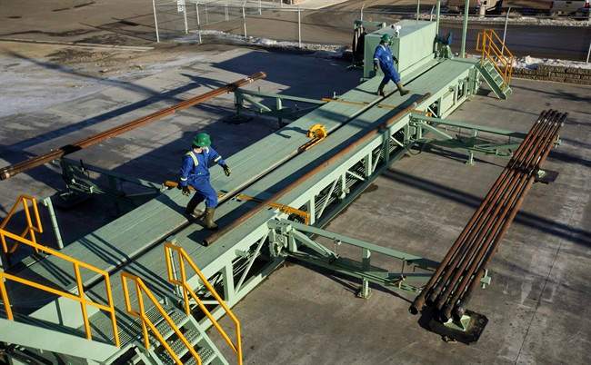Trainees roll pipe off the catwalk during a training session to lay down drill pipe on a rig floor at Precision Drilling in Nisku, Alta., in a January 20, 2017, file photo. 