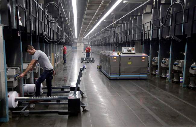 Workers and robots labour side-by-side with plastic thread made from recycled bottles at the Repreve Bottle Processing Center, part of the Unifi textile company in Yadkinville, N.C., in an October 21, 2016, file photo. 