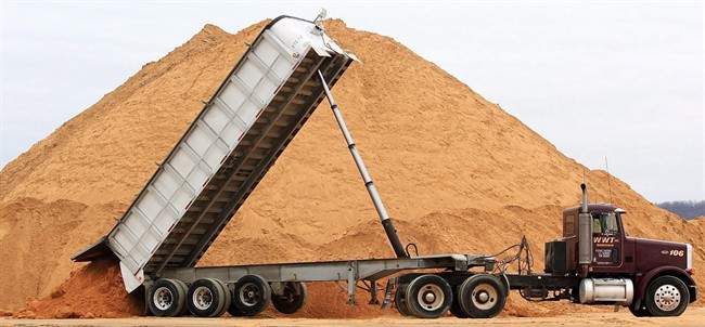 A truck dumps a load of silica sand at Modern Transport Rail loading terminal in Winona, Minn., on Feb. 13, 2012.  