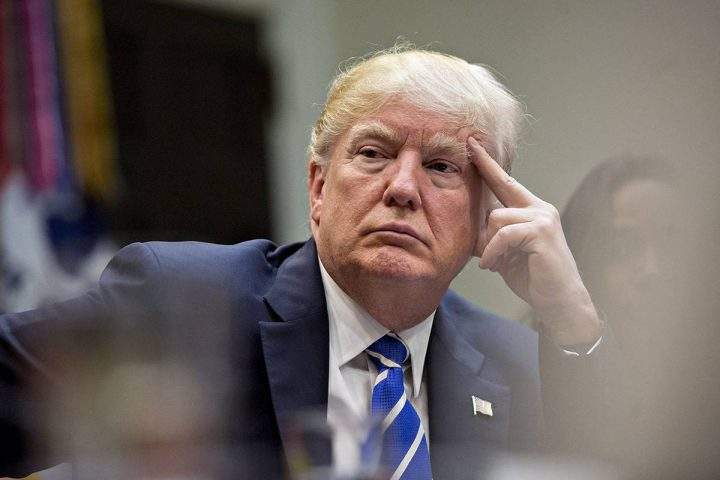U.S. President Donald Trump listens while meeting with women who are small-business owners.