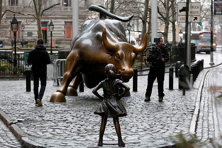 A cameraman films a statue of a girl facing the Wall St. Bull in the financial district in New York, U.S., March 7, 2017.