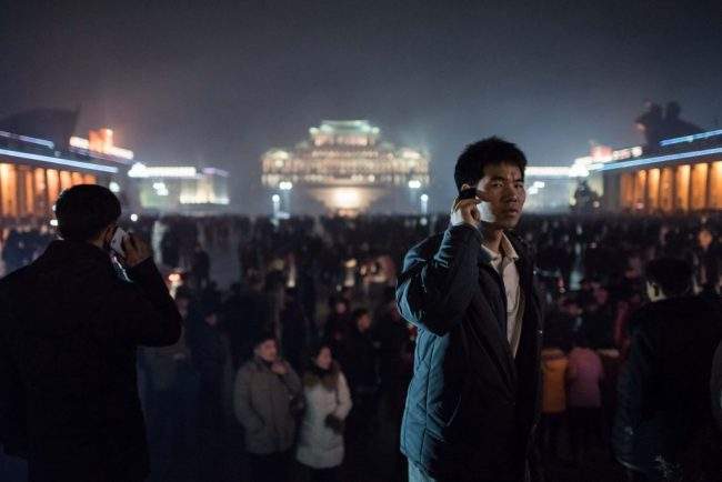 A man talks on a mobile phone after a fireworks display in front of Kim Il-Sung square, and next to an ice festival near the Taedong river, on the occasion of the 75th anniversary of the birth of Kim Jong-Il, in central Pyongyang on February 16, 2017.

