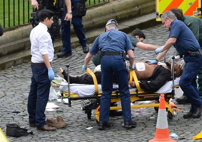 In this March 22, 2017 file photo, the attacker Khalid Masood is treated by emergency services outside the Houses of Parliament London.