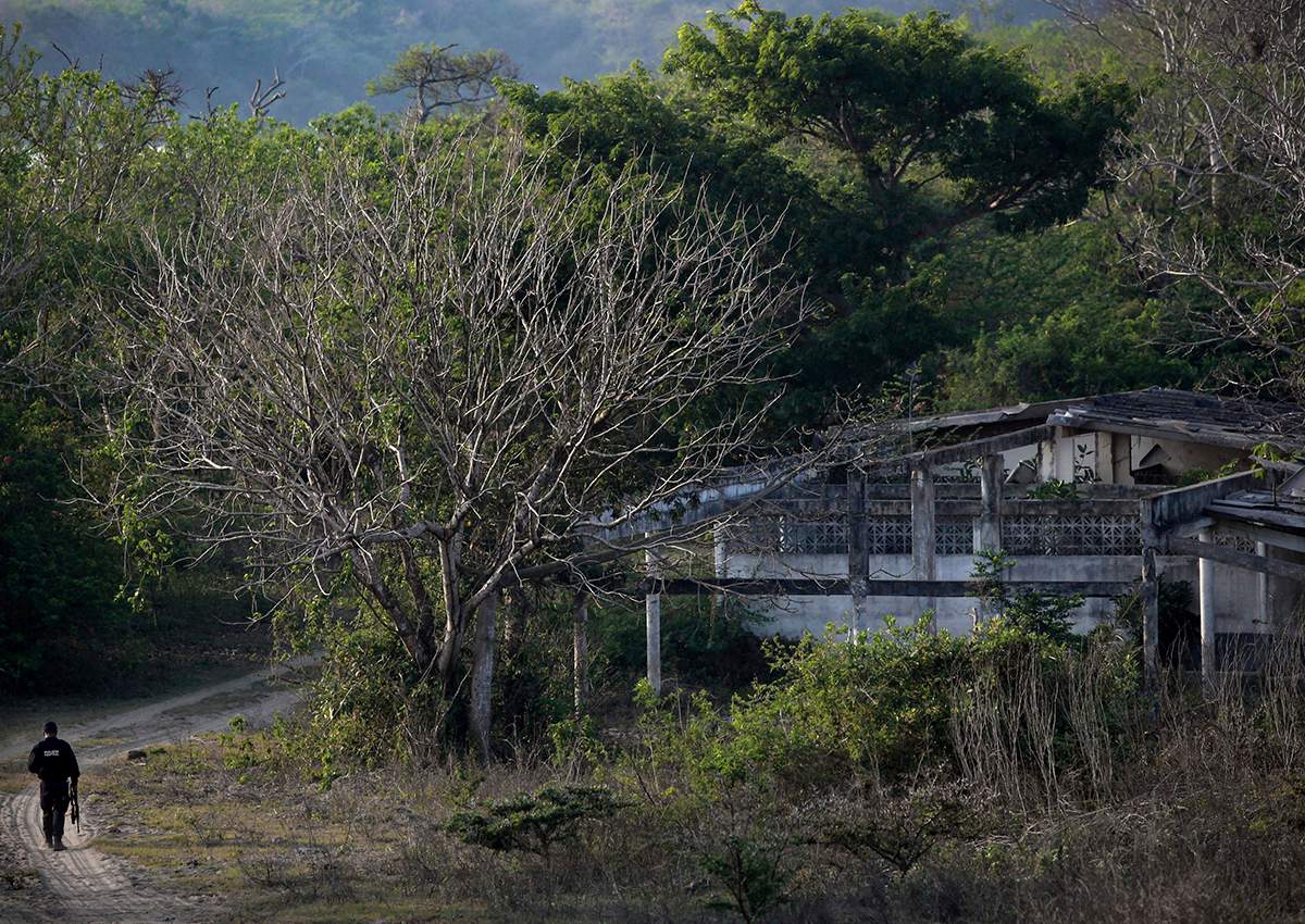 In this April 11, 2015 photo, a federal police officer walks in an area known as Colinas de Santa Fe on the outskirts of Veracruz, Mexico. 