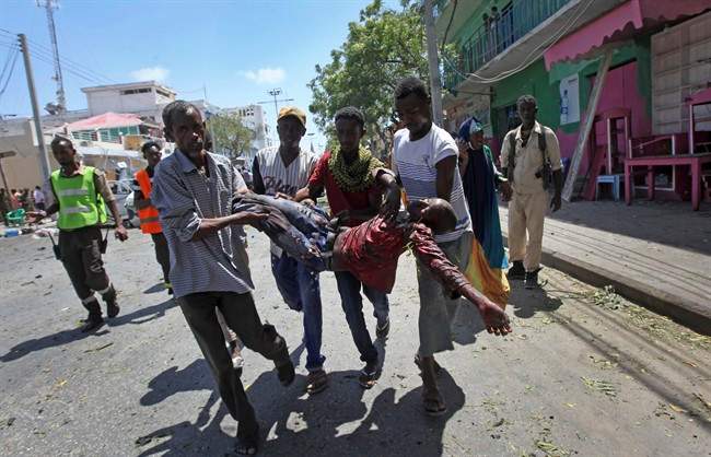 Rescuers carry away a man who was wounded in a car bomb attack in Mogadishu, Somalia Monday, March 13, 2017. A suicide car bomber detonated near the Weheliye hotel in the capital Monday morning, killing a number of people on the busy Maka Almukarramah road, police said. (AP Photo/Farah Abdi Warsameh).