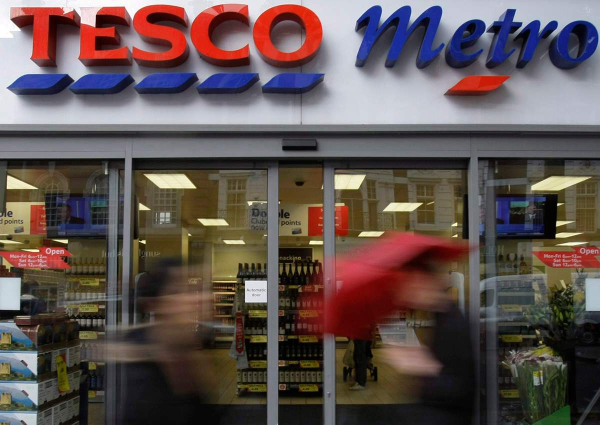  In this file photo dated Tuesday, Oct. 6, 2009, people pass by a branch of British retailer supermarket Tesco, in London. 