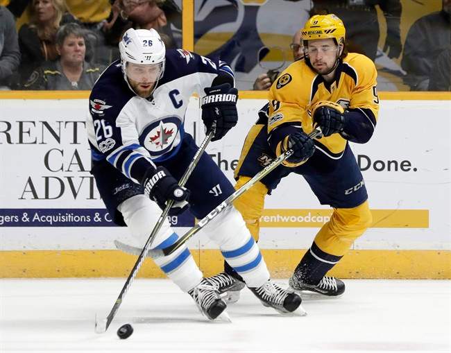 Winnipeg Jets right wing Blake Wheeler (26) and Nashville Predators left wing Filip Forsberg (9), of Sweden, battle for the puck during the second period of an NHL hockey game Monday, March 13, 2017, in Nashville, Tenn. 