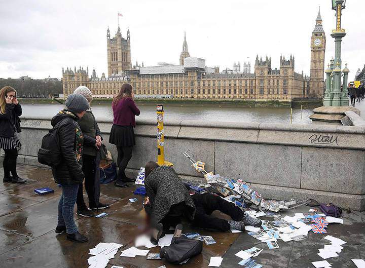An injured woman is assisted after an incident on Westminster Bridge in London, Britain March 22, 2017.