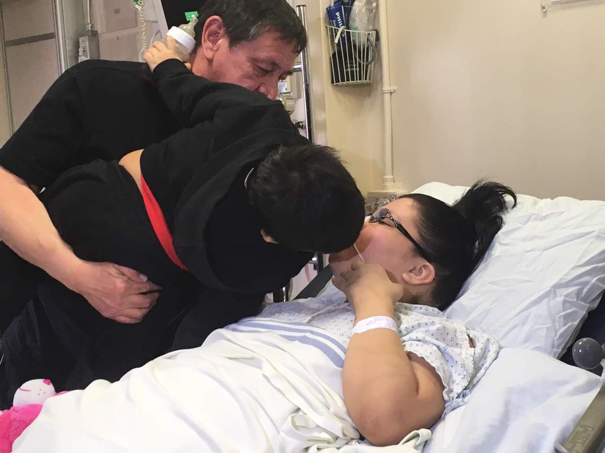 Cari Kirkness reaches over to comfort her son and give him a kiss as she remains in hospital recovering from a triple amputation.