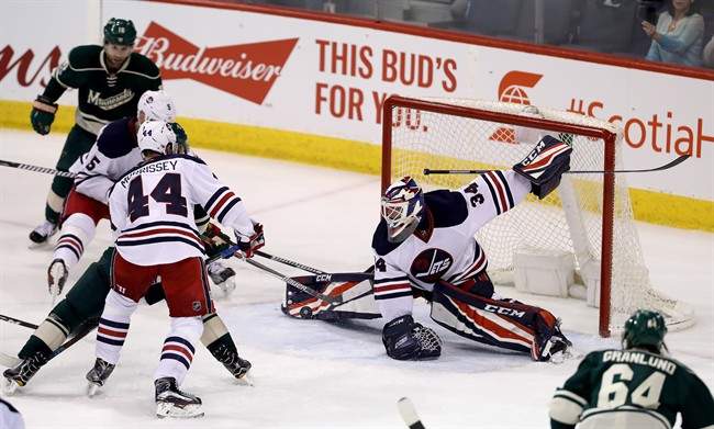 Winnipeg Jets goaltender Michael Hutchinson (34) stretches out to make a save against the Minnesota Wild during third period NHL hockey action in Winnipeg, Sunday, March 19, 2017.