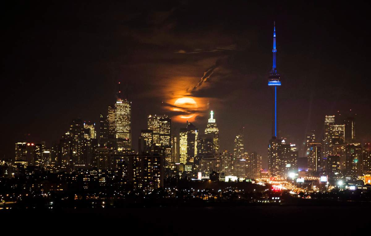 The full moon rises over the Toronto skyline in Toronto on Nov. 14, 2016.