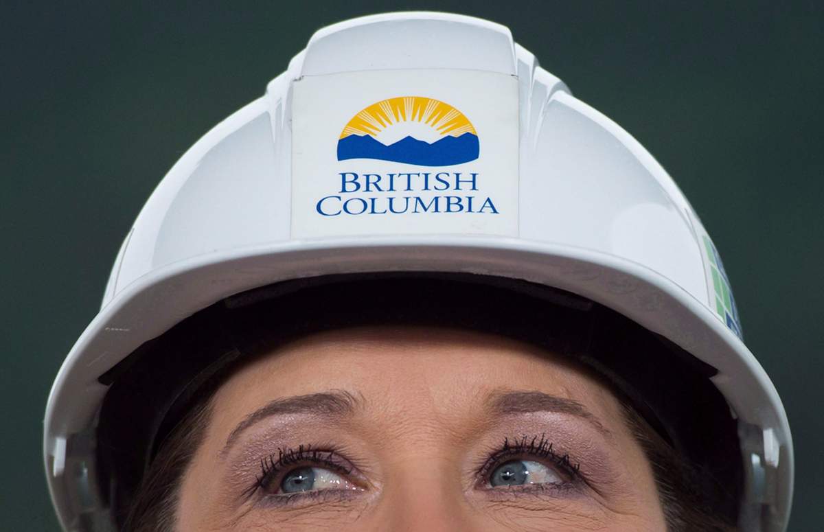 Wearing a hard hat, B.C. Premier Christy Clark listens to a question at the Woodfibre LNG project site near Squamish, B.C., on Friday November 4, 2016. 