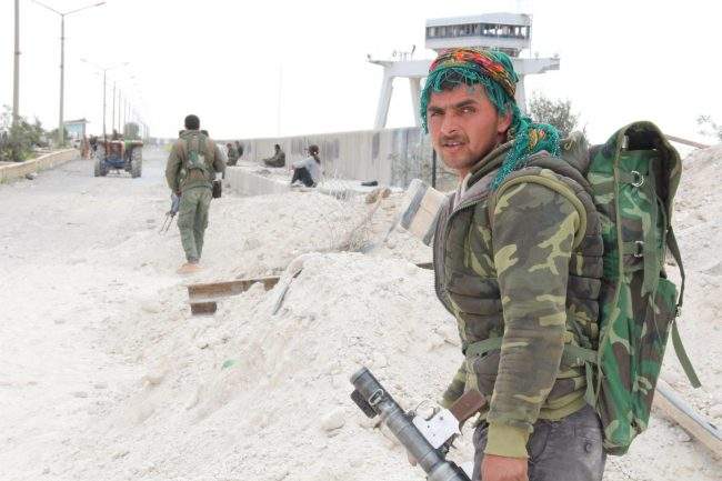 Members of the coalition forces take up positions nearby of the Euphrates dam where engineers opened one of the turbines on 30 March 2017, to ease the water pressure as the battles continue to control the entire dam so far. 