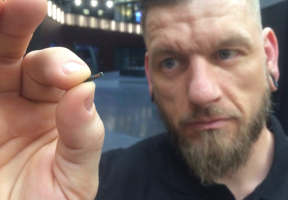 Self-described ”body hacker,” Jowan Osterlund from Biohax Sweden, holds a small microchip implant, similar to those implanted into workers at the Epicenter digital innovation business centre during a party at the co-working space in central Stockholm, Tuesday March 14, 2017.