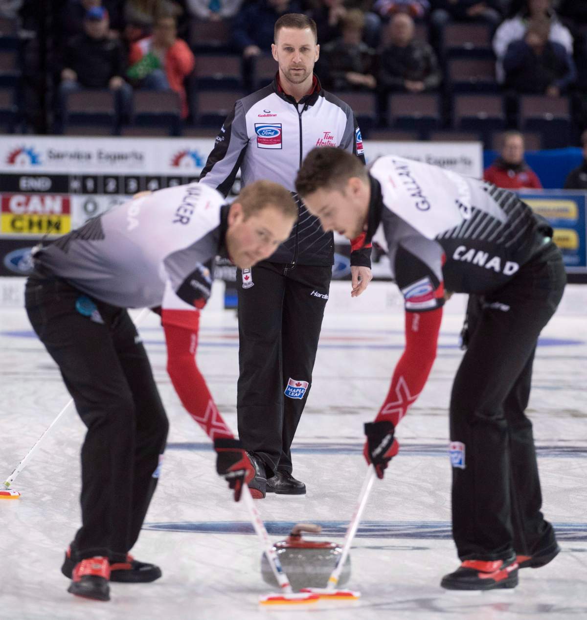 Canada skip Brad Gushue watches his shot as lead Geoff Walker (left) and second Brett Gallant sweep during the 10th draw against China at the Men’s World Curling Championships in Edmonton, Tuesday, April 4, 2017. THE CANADIAN PRESS/Jonathan Hayward
